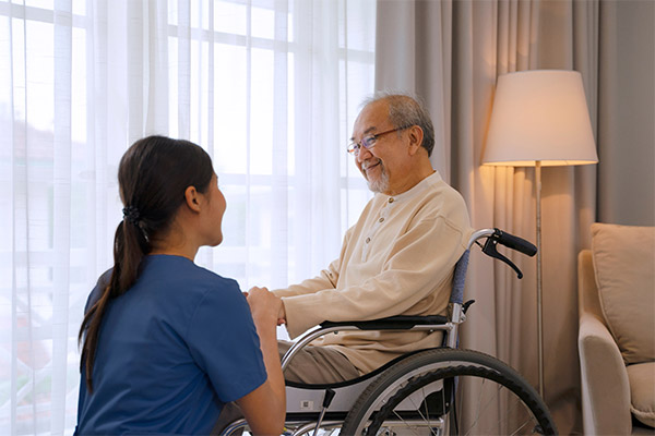 Agile_CareOptions_3 gentleman in wheelchair with caregiver